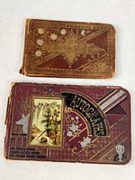 Front covers of both autograph books showing decorative designs