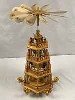 Full view of multi-tier wooden Christmas pyramid showing rotor, tiers, candle holders