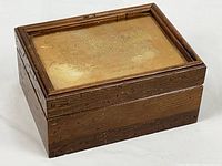 Closed wooden box showing brass lid plate