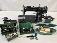 Full lot view showing sewing machine, buttonholer cases, oval case, pedal, knee lever, bracket