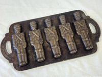 Top view of cast iron pan showing five toy soldier molds