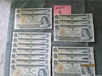 Group of 20 Canadian $1 bills laid out, two stacks and pair to right