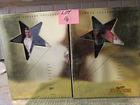 Front view of both gold star-window boxes showing Ken and Barbie dolls