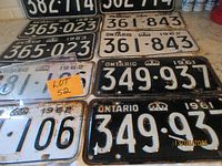 Overview of multiple licence plate pairs, three black-background pairs upper rows, white 1962 pair and black 1961 pair lower rows