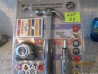 Front view of sealed NHL tool set showing hammer, tape measure, screwdriver and logo caps