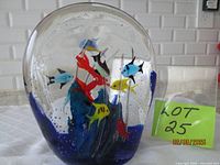 Front view of Murano glass paperweight displaying colourful fish inside