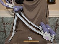 Full view of ab cruncher showing frame, rollers, handle and display