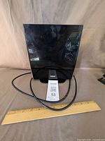 Front view of black flat panel Terk antenna with coaxial cable and ruler for scale