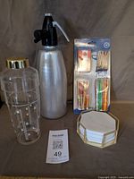 Full lot: shaker, soda siphon, umbrella pick pack, marble coasters in holder