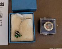 Both pins: Eastern Breeders service pin in blue box interior and National Breeders Association pin in plastic case