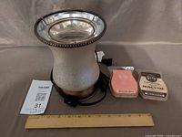 Warmer, two wax melt packs, power cord, ruler for scale