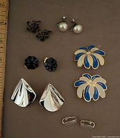 All six earring pairs laid out with ruler for scale