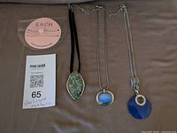 All necklaces laid out: packaged set and three pendant necklaces
