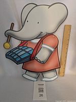 Front view of Babar foamboard decoration with ruler for scale and lot tag