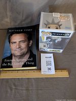 Book and boxed Funko Pop figure with ruler for scale