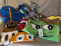 Overall lot: two M&M fleece blankets and knitted teddy bear displayed on surface