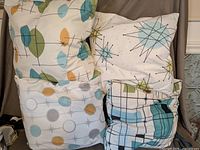 Front view of four Mid-Century Modern style throw pillows