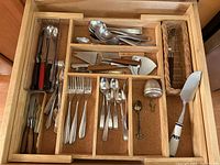 Drawer overview showing flatware, steak knives, serving utensils, tea infuser and chopsticks