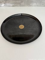 top view of black round tray with gold chrysanthemum motif