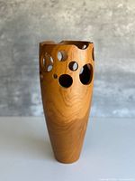 full view of vase front showing pierced design and wood grain