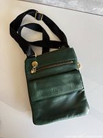 Full view of green leather crossbody with strap