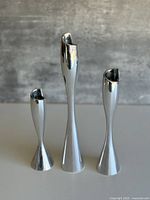 Front view of three graduated Nambe spiral candlestick holders