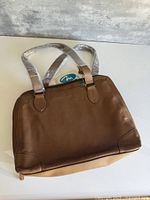 Full view of brown leather tote with handles wrapped