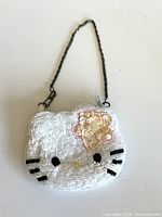 Front view showing beaded surface, flower accent and wrist chain