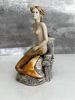 Front left view of mermaid figurine on piling base