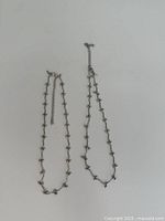 Two silver-tone beaded link necklaces laid flat showing overall design and extenders