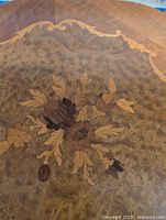 Top view showing burl veneer and floral marquetry inlay with lighter border
