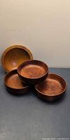 Four wooden bowls grouped together showing interior grain and shape