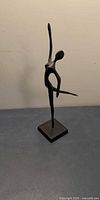 Front view of metal abstract dancer figurine on square base