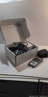 Open box displaying BlackBerry phone, cables, and pouch