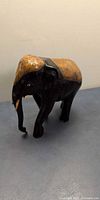 Left side view of carved wooden elephant figurine