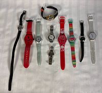 All ten Swatch watches laid out flat showing variety of bands and cases