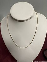 Full view of gold chain on display bust