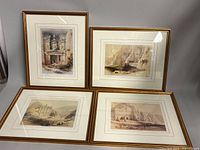 All four framed lithographs displayed on table