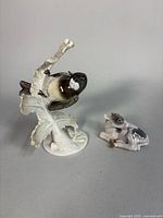 Both figurines side by side: bird on branch and calf