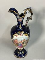 Three-quarter view of porcelain ewer showing overall shape, cobalt glaze and figural scene