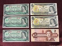 Six Canadian banknotes laid out: 3×1967 $1, 2×1973 $1, 1×1986 $2