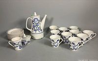 Full set showing teapot, sugar bowl, creamer, stack of saucers, and grouped teacups