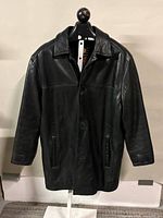 Front view of black leather coat on stand