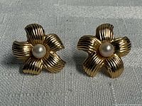 Front view of both gold flower stud earrings with pearls