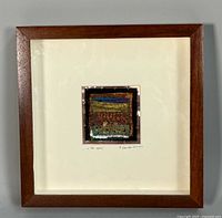 Full view of framed artwork showing brown wood frame, white mat, central mixed media piece, artist signature and title visible