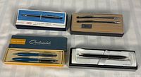 Four boxed pen sets laid out