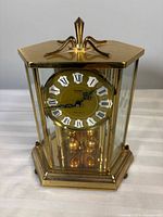Front angled view showing overall brass and glass mantle clock