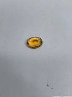Top view of oval citrine on white background showing color and clarity