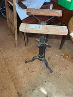 Full view of cast iron pedestal base with wood planks on top