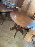 Full view of oval solid wood table in front of background furniture